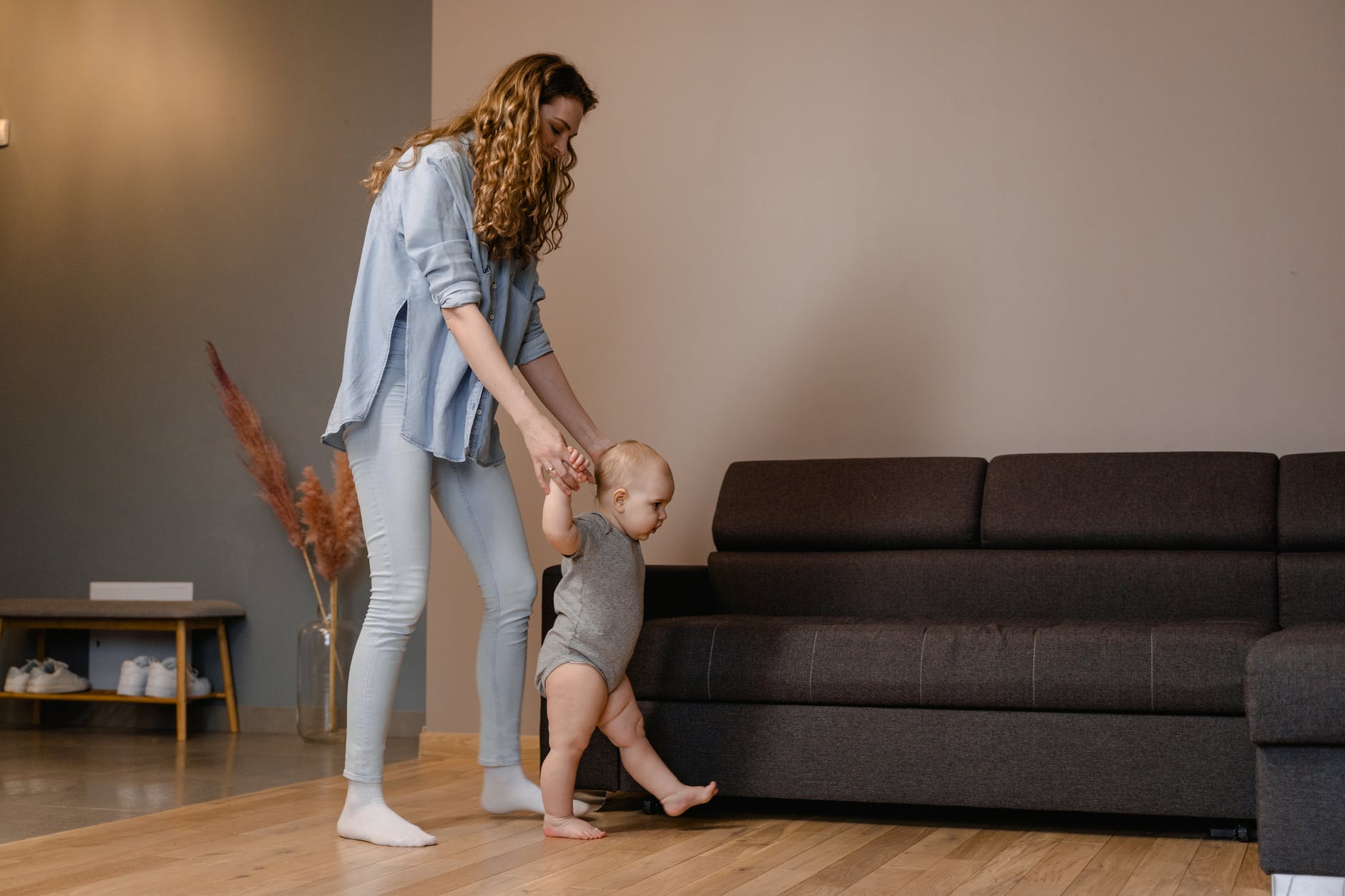 mother educating baby to walk step by step