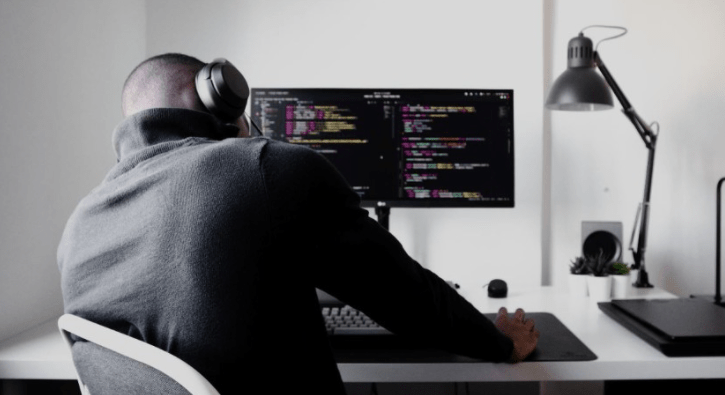 Men listening music coding on computer
